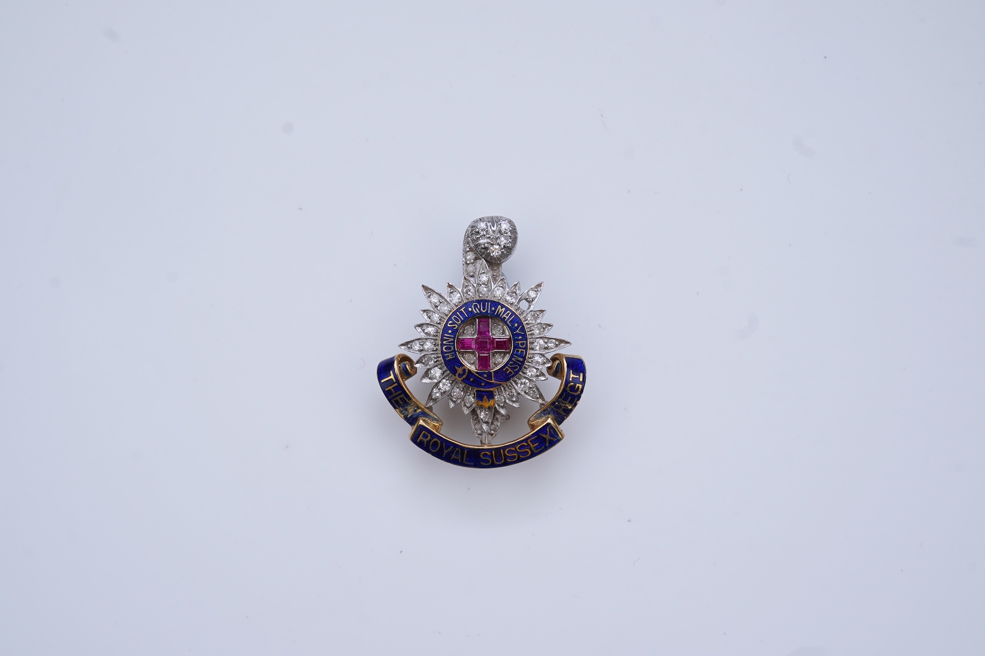 A ruby, enamel and diamond Royal Sussex Regiment badge, mid 20th century